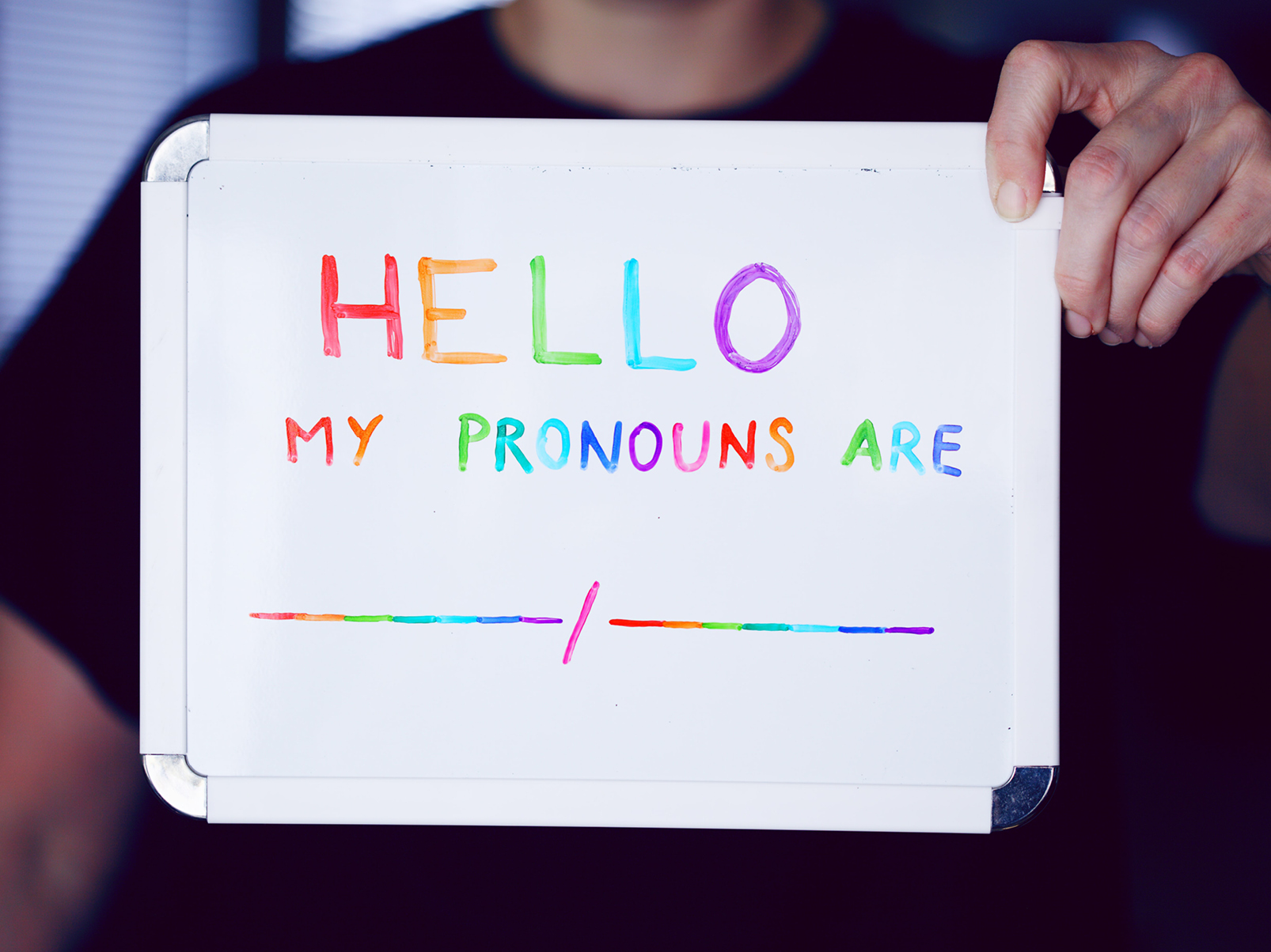 White board with, "Hello. My pronouns are [blank]," in a rainbow ink. 